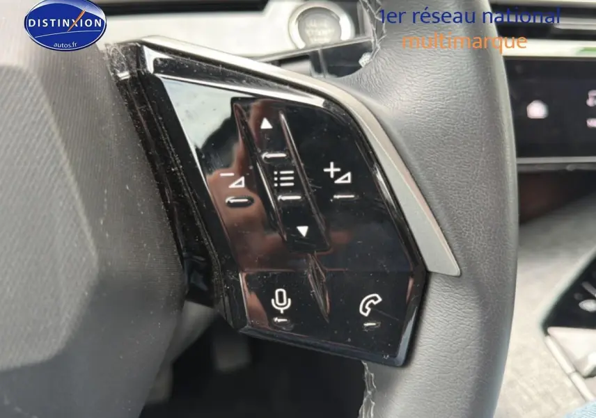 Gros plan sur les commandes multifonctions noires du volant cuir du Peugeot 3008 gris titane, version 2025.