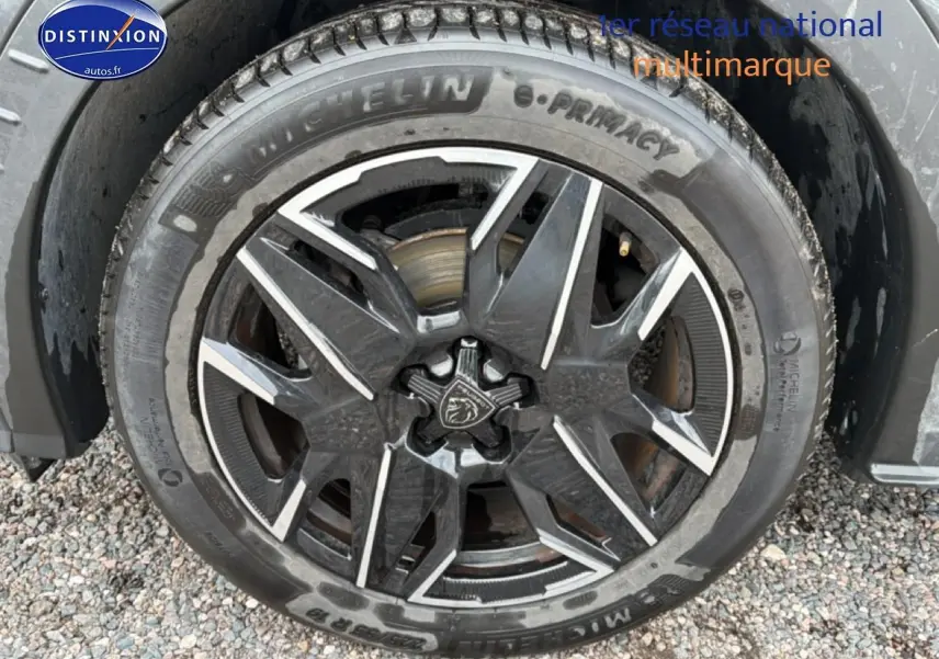 Gros plan sur la jante alu noire et argentée du Peugeot 3008 gris titane, avec pneu Michelin visible.