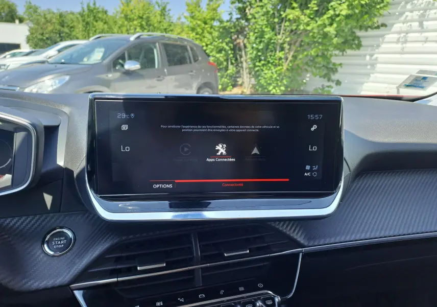 Vue rapprochée de l'écran tactile central et du tableau de bord intérieur noir du Peugeot 2008 rouge, avec bouton start visible.