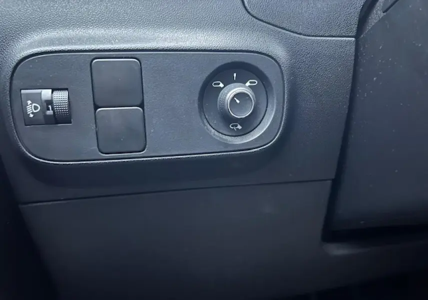 Gros plan sur les commandes de réglage des rétroviseurs côté conducteur d'une Citroën C3 Shine 2023 noir toit rouge.