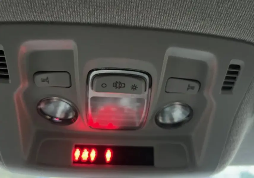 Plafonnier intérieur avec commandes d'éclairage et indicateurs rouges dans une Citroën C3 Shine 2023 noir toit rouge.