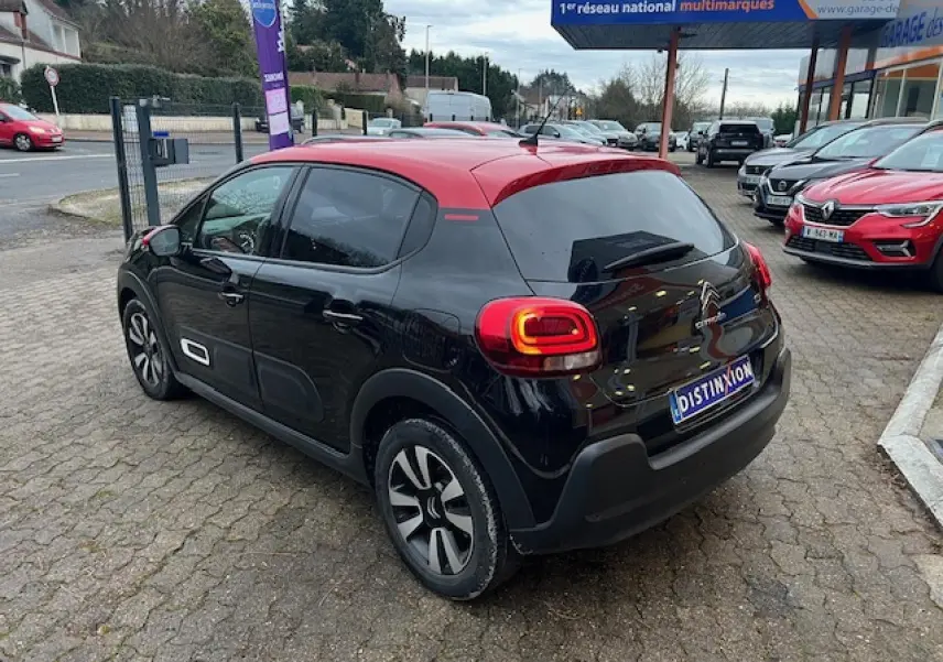 Citroën C3 Shine 2023 vue 3/4 arrière côté gauche, noir avec toit rouge et jantes alliage diamantées.