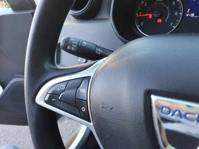 Gros plan sur le volant noir du Dacia Duster 2021 avec commandes intégrées et tableau de bord partiellement visible.