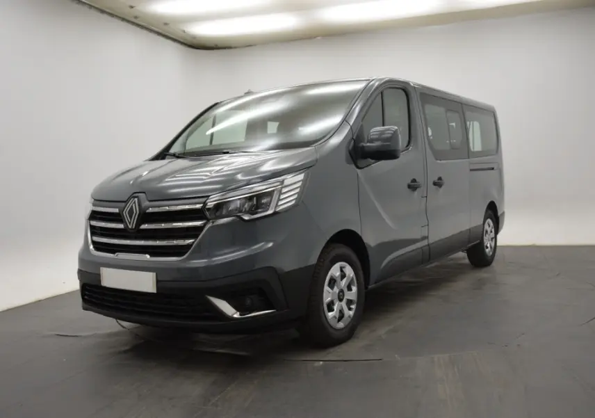 Renault Trafic Fourgon gris clair vu en 3/4 avant droit, avec calandre chromée et phares LED allumés.