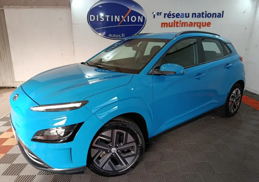 Vue 3/4 avant d'un Hyundai Kona électrique bleu vif avec jantes spécifiques et rétroviseurs assortis.
