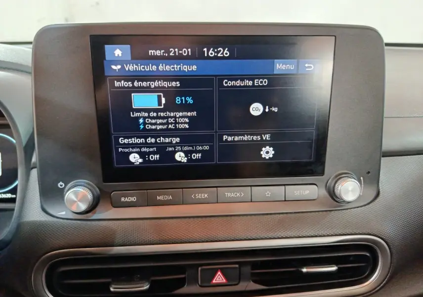 Écran tactile central affichant les infos de charge d’une Hyundai Kona électrique, vue de face intérieur.