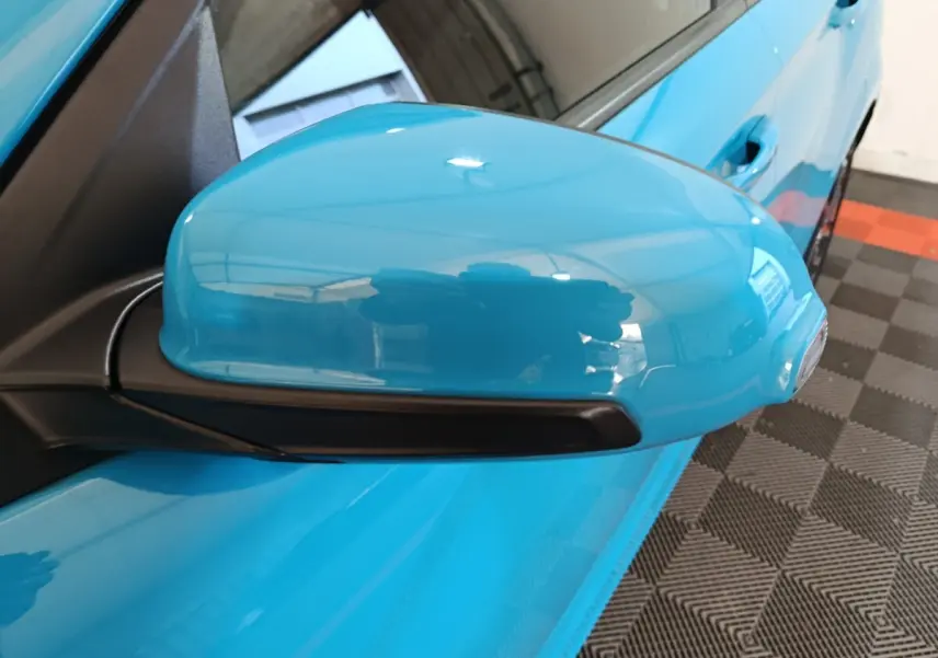 Rétroviseur côté gauche bleu électrique du Hyundai Kona BEV 64kWh 2022, vue rapprochée sur la portière et poignée.