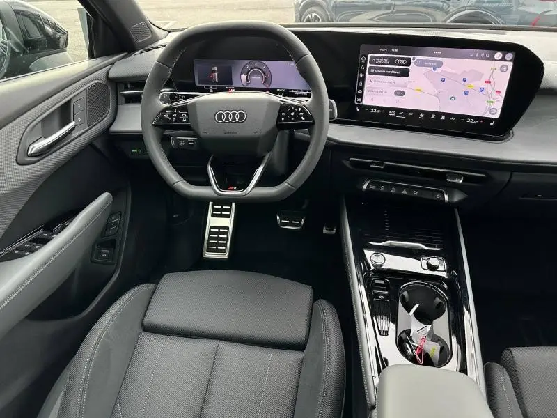 Vue intérieure avant de l'Audi Q3 2026 noir Mythique, volant cuir multifonction et écran tactile GPS large.