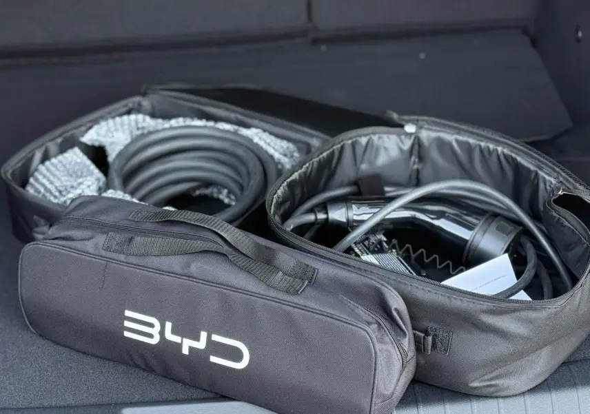 Sac de rangement noir BYD ouvert dans le coffre avec câble de recharge pour BYD SEAL U Snow White.