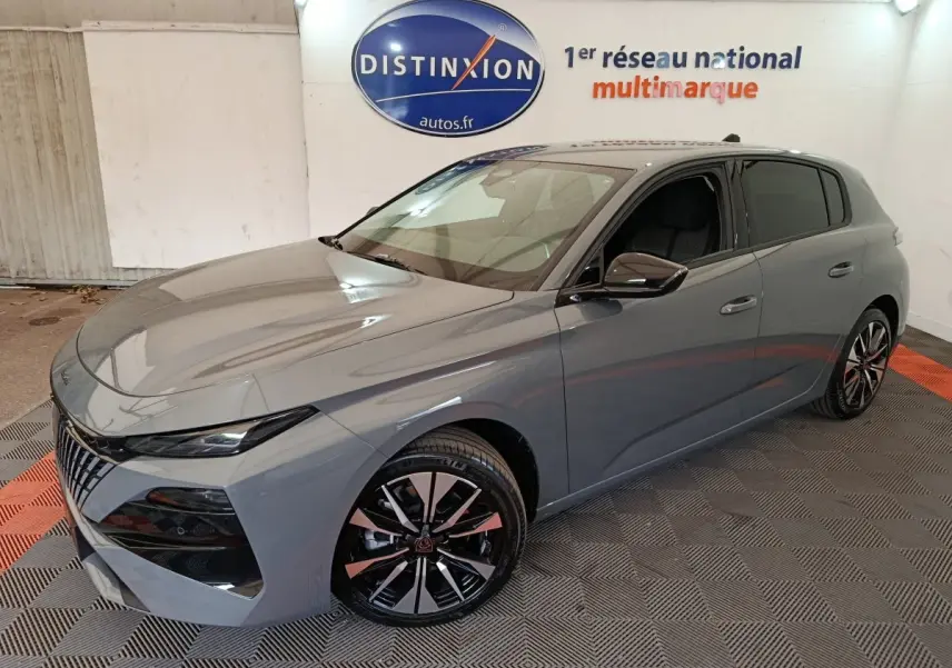 PEUGEOT 308 BlueHDi 130 gris foncé en 3/4 avant droit, avec jantes alliage et calandre distinctive.