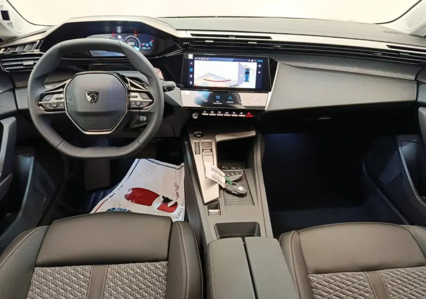 Intérieur Peugeot 308 BlueHDi 130 2026 vu de face, volant cuir multifonctions et écran tactile central allumé.
