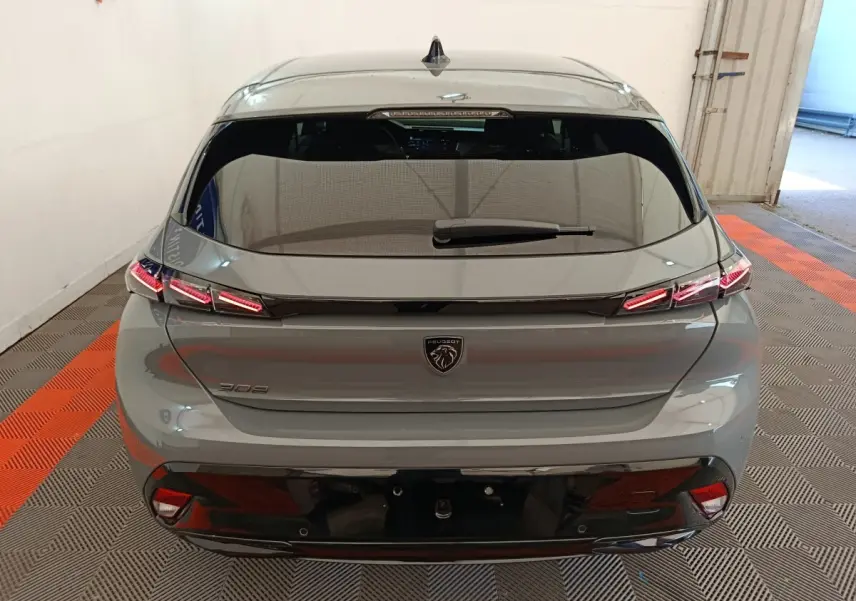 Vue arrière d'une Peugeot 308 gris foncé avec feux LED distinctifs et lunette arrière teintée.