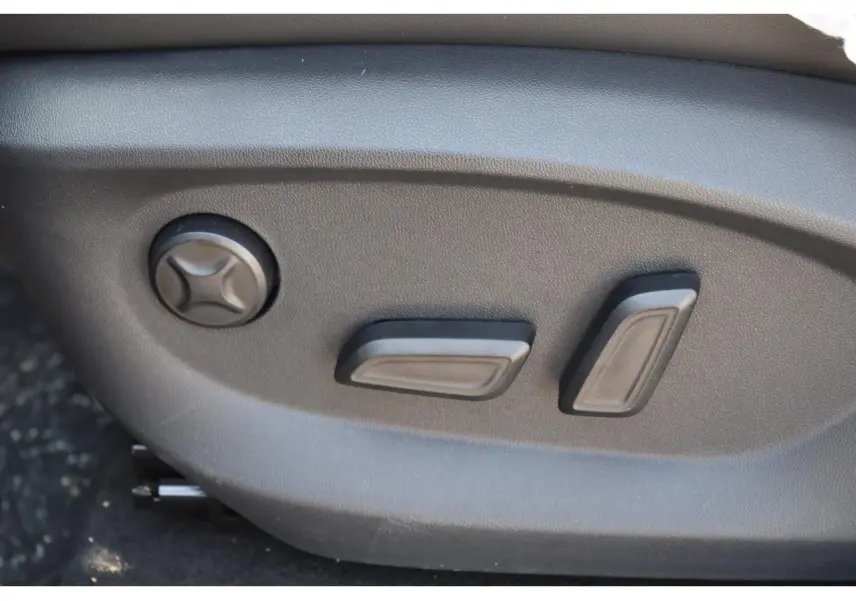 Gros plan sur les commandes électriques de réglage du siège conducteur du MG MOTOR EHS 1.5 Hybrid+ noir.