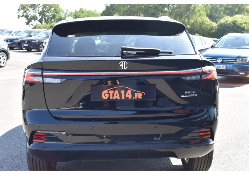 Vue arrière d’un MG MOTOR EHS 1.5 Hybrid+ noir avec feux LED et badge Hybrid visible sur un parking.