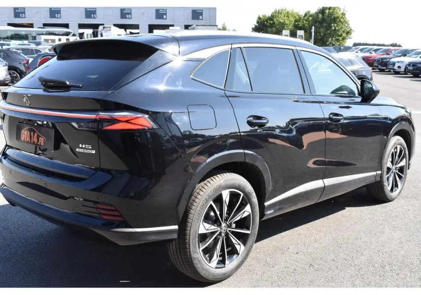 Vue 3/4 arrière droite du SUV MG EHS noir métallisé avec jantes alliage et feux arrière LED allumés.