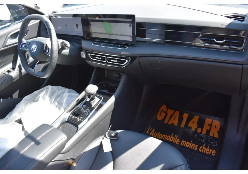 Vue intérieure côté passager du tableau de bord et console centrale du MG Motor EHS 1.5 Hybrid+ noir avec écran tactile panoramique.