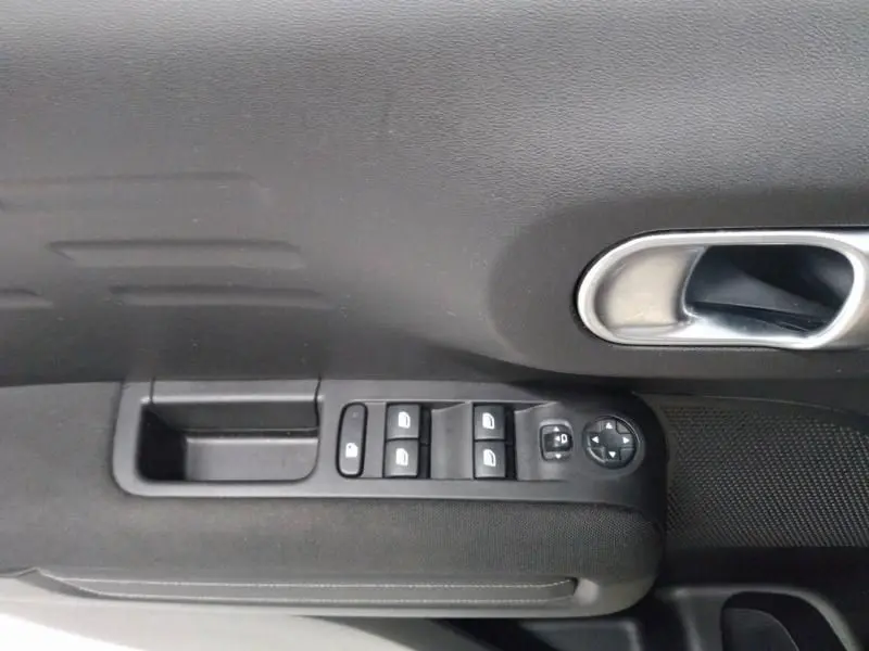 Commande des vitres et rétroviseurs côté conducteur dans une Citroën C3 Aircross gris 2022 finition Shine Pack.