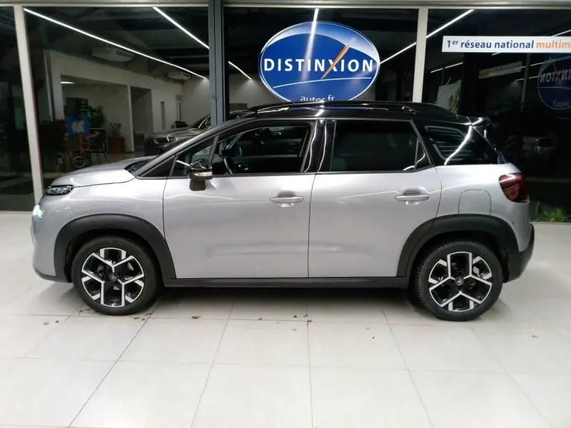 Profil côté gauche d'un Citroën C3 Aircross gris 2022 avec toit noir et jantes alliage distinctives.