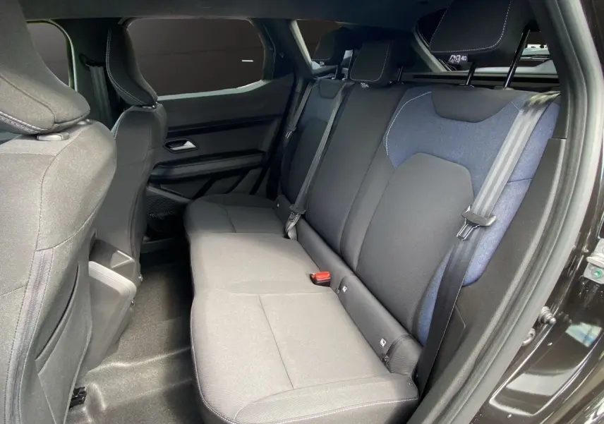 Vue intérieure côté droit des sièges arrière en tissu noir et bleu du Dacia Duster hybride 2025.