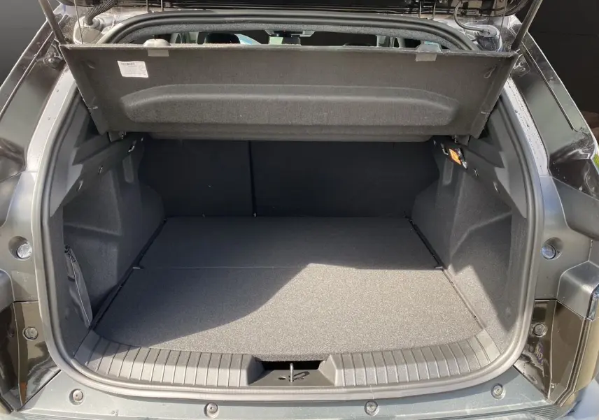 Coffre ouvert du Dacia Duster hybride noir 2025, montrant un espace de chargement plat et bien fini.