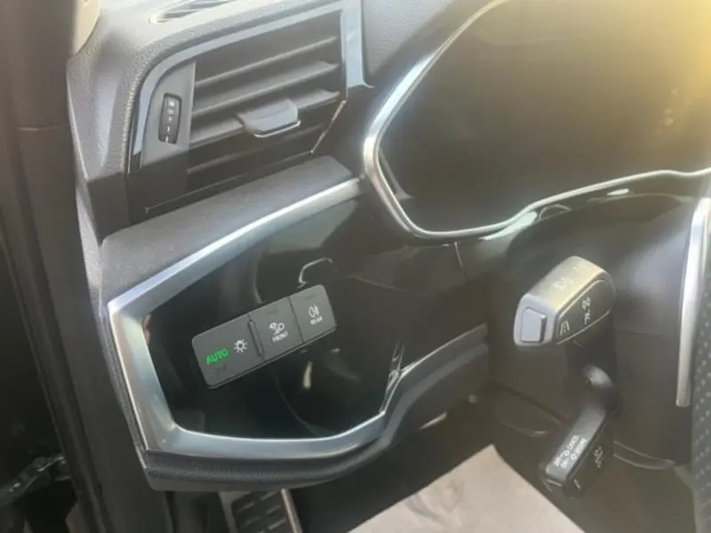 Détail du tableau de bord côté gauche de l'Audi RS Q3 Sportback noir avec commandes d'éclairage et régulateur de vitesse.