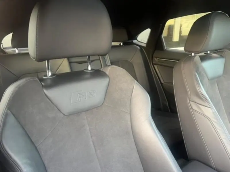 Gros plan sur les sièges avant sport en cuir et alcantara avec logo RS de l'Audi RS Q3 Sportback noir Mythic.