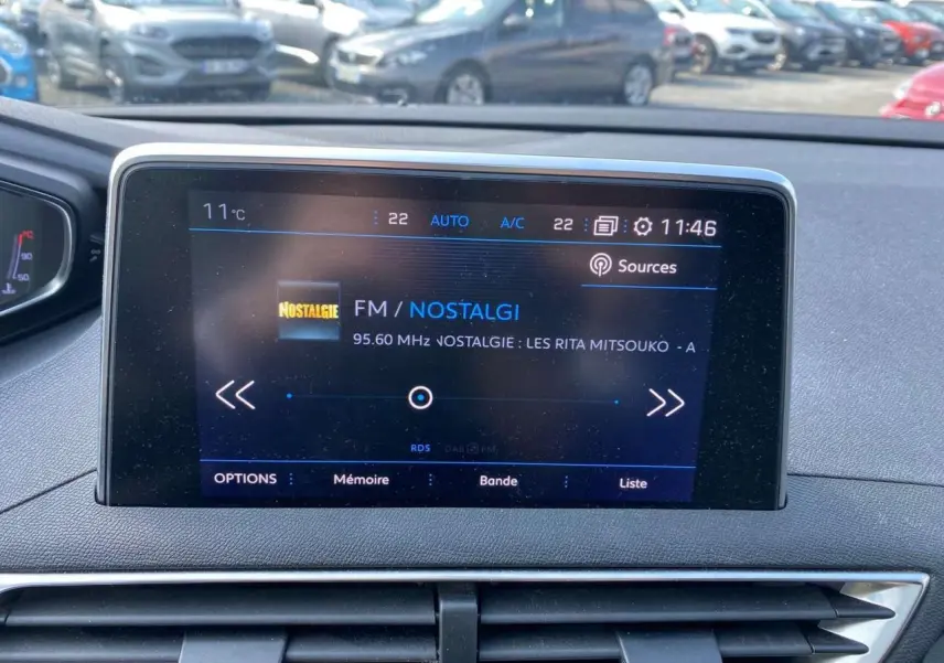 Écran tactile central du Peugeot 3008 blanc 2018 affichant la radio FM Nostalgie à 11h46 en extérieur.