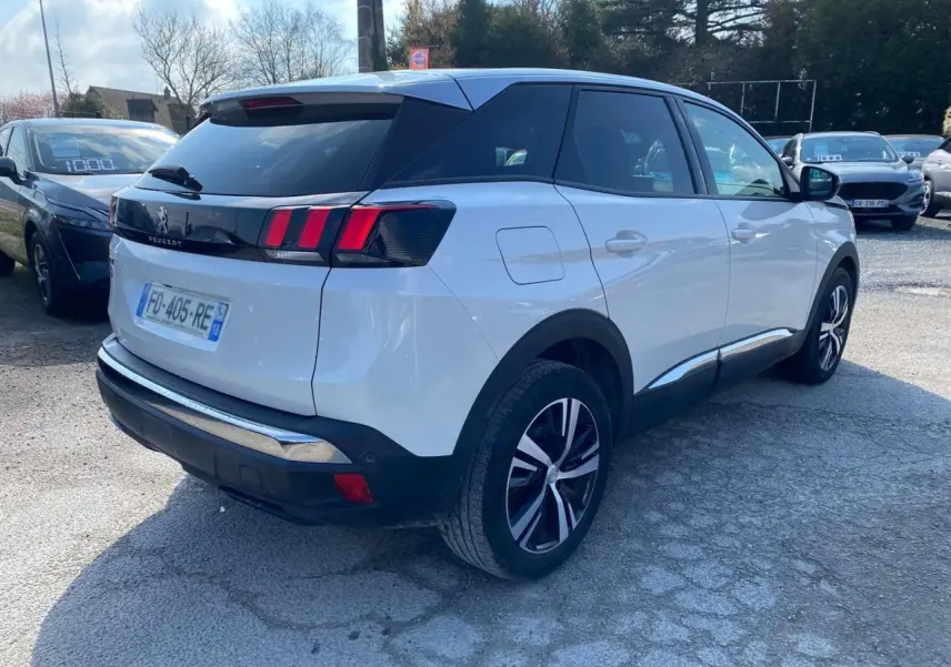 Vue 3/4 arrière droite d'un Peugeot 3008 blanc Banquise avec vitres surteintées et feux arrière à trois griffes rouges.