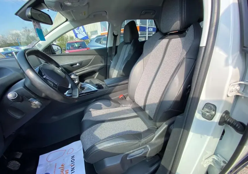 Intérieur avant droit du Peugeot 3008 blanc 2018, sièges en tissu et cuir noir avec tableau de bord visible.