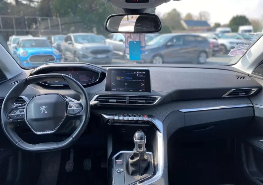 Intérieur du Peugeot 3008 blanc 2018 vu de face, tableau de bord moderne avec écran central et boîte manuelle.