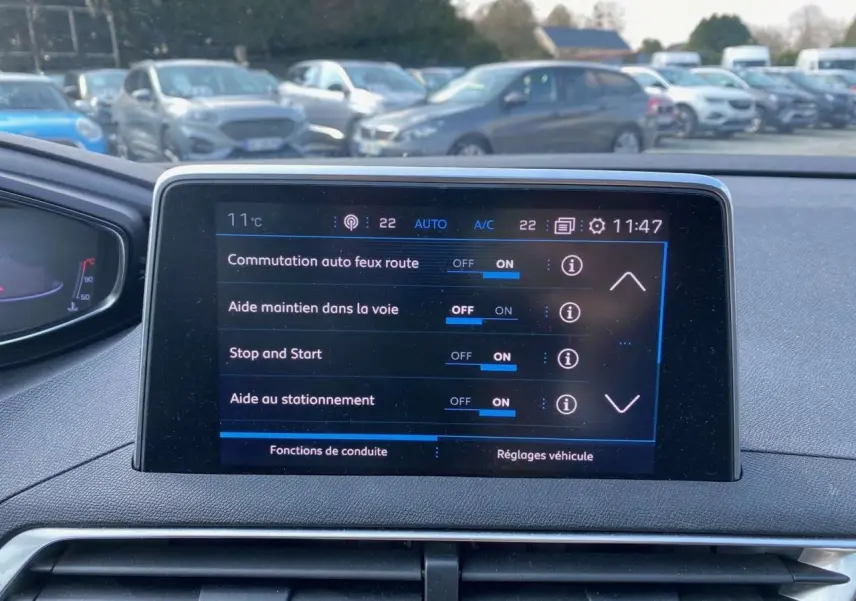 Écran tactile central du tableau de bord du Peugeot 3008 blanc de 2018 affichant les aides à la conduite activées.