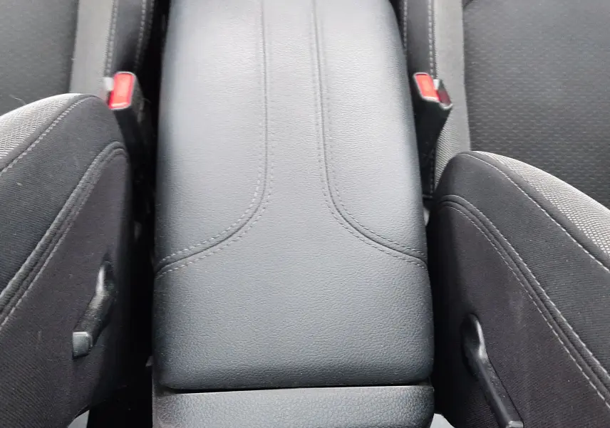 Vue rapprochée de l'accoudoir central noir en cuir entre les sièges avant en tissu gris du Nissan Qashqai DCI 115 N-Connecta 2020.