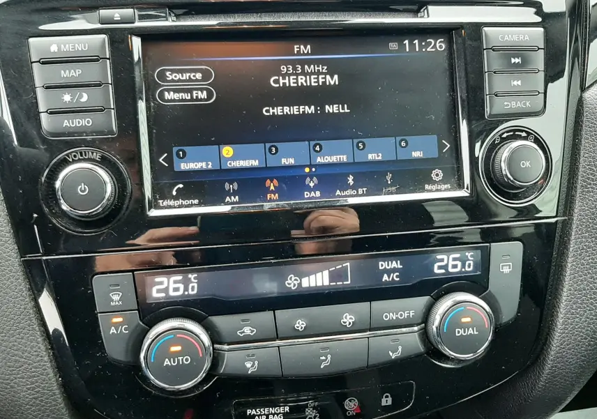 Vue rapprochée de la console centrale du Nissan Qashqai DCI 115 N-Connecta 2020, affichant l’écran multimédia et la climatisation digitale.