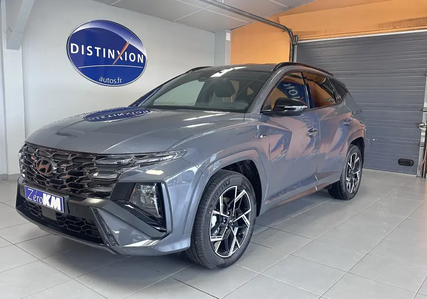 Intérieur du Hyundai Tucson 2025 vu côté passager, écran tactile multimédia allumé avec ambiance lumineuse bleue.