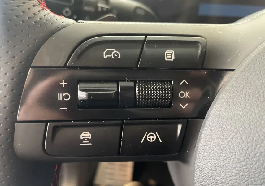 Gros plan sur la commande des feux et clignotants à gauche du volant d’un Hyundai Tucson gris Ecotronic 2025.