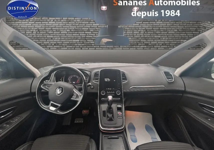 Vue intérieure avant du Renault Scénic 2020, tableau de bord noir avec écran tactile vertical et volant multifonctions.