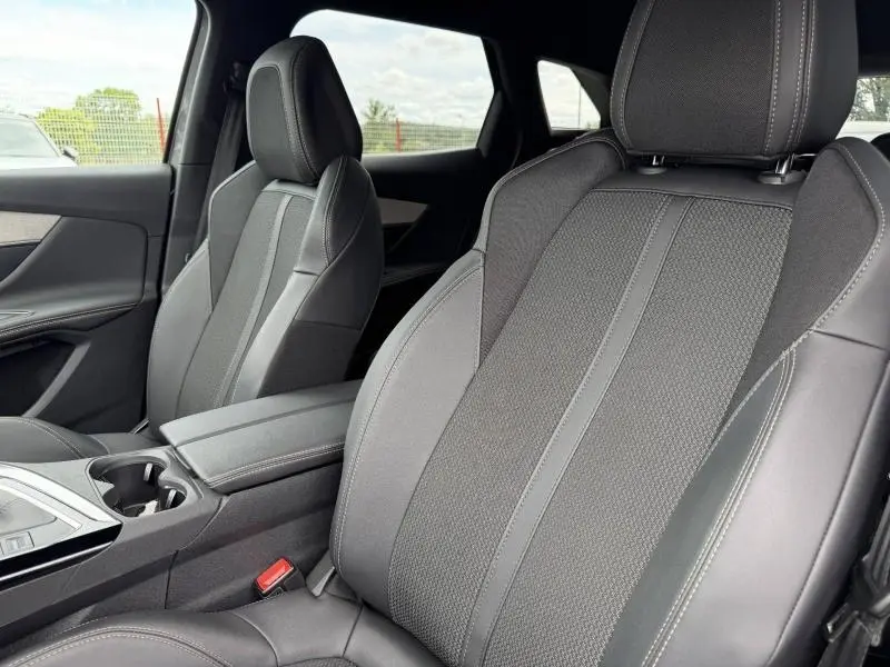 Gros plan sur les sièges avant en tissu et cuir noir du Peugeot 3008 2024, vue côté droit intérieur.