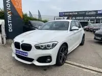 BMW Série 1 114d M Sport blanche vue en 3/4 avant droit, avec jantes sport et calandre caractéristique.