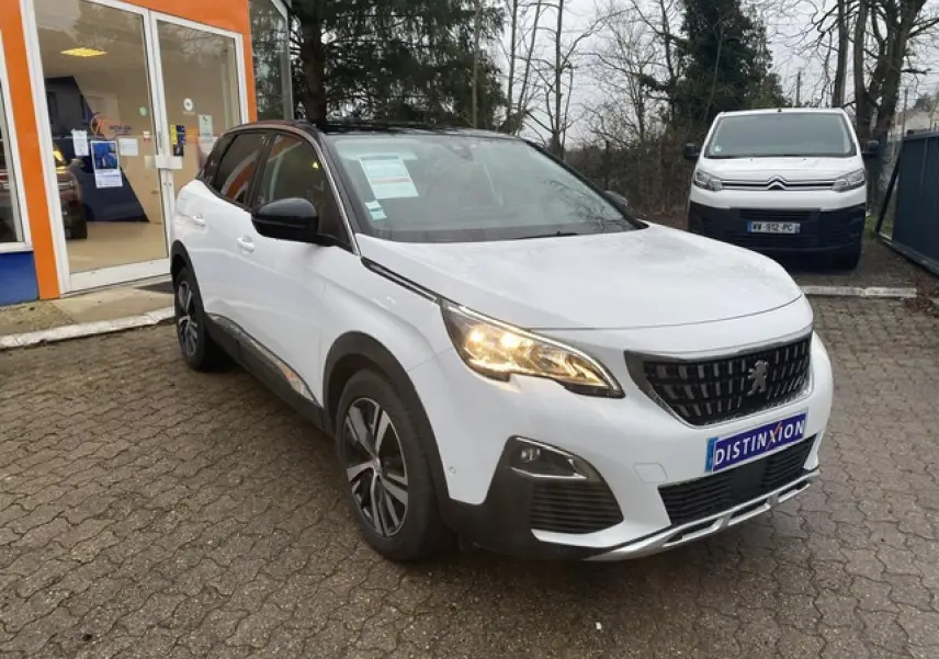 Peugeot 3008 blanc vue 3/4 avant droit avec toit noir et jantes alliage bi-ton sur parking extérieur.
