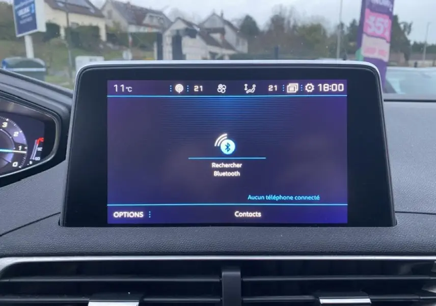 Écran tactile central du tableau de bord du Peugeot 3008 blanc, affichant la recherche Bluetooth en intérieur.