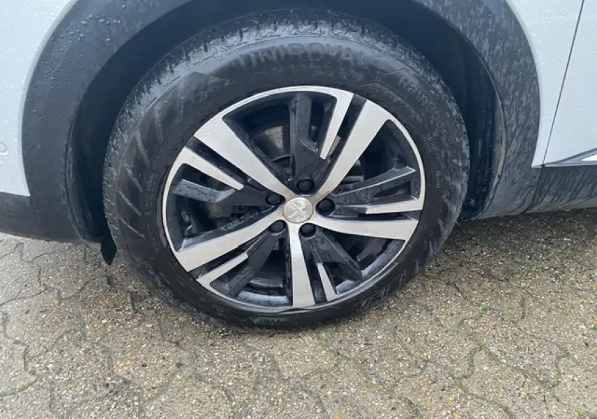 Gros plan sur la jante alliage bi-ton diamantée 18 pouces côté arrière droit du Peugeot 3008 blanc.