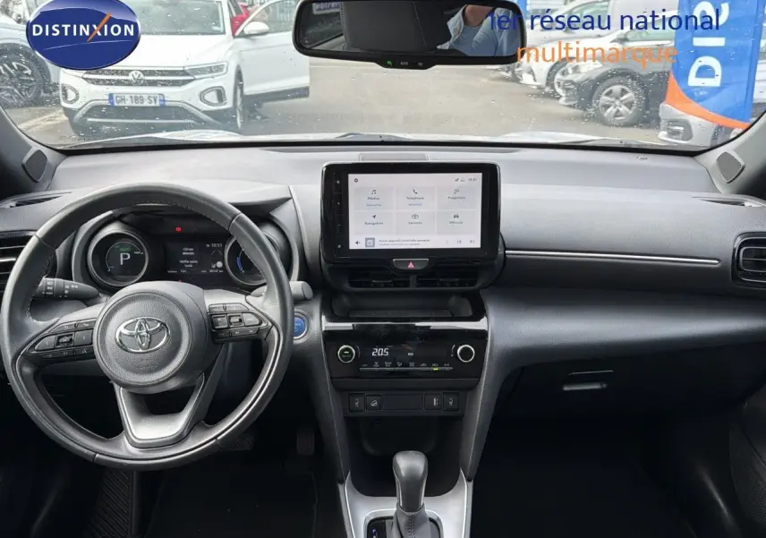 Vue intérieure du tableau de bord noir de la Toyota Yaris Cross 116h Design AWD-i avec écran tactile central et volant multifonction.