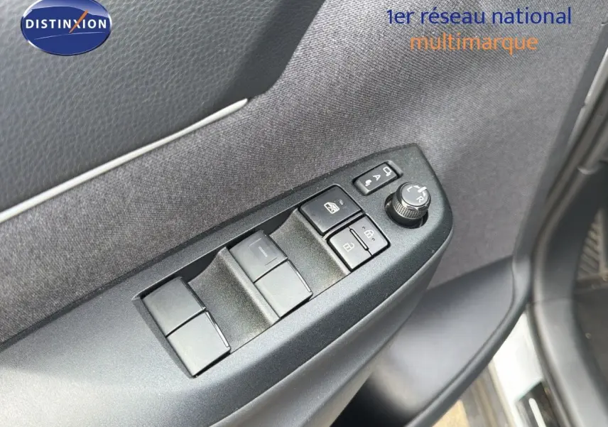 Gros plan sur les commandes des vitres et rétroviseurs côté gauche de la porte d'une Toyota Yaris Cross gris minéral 2023.