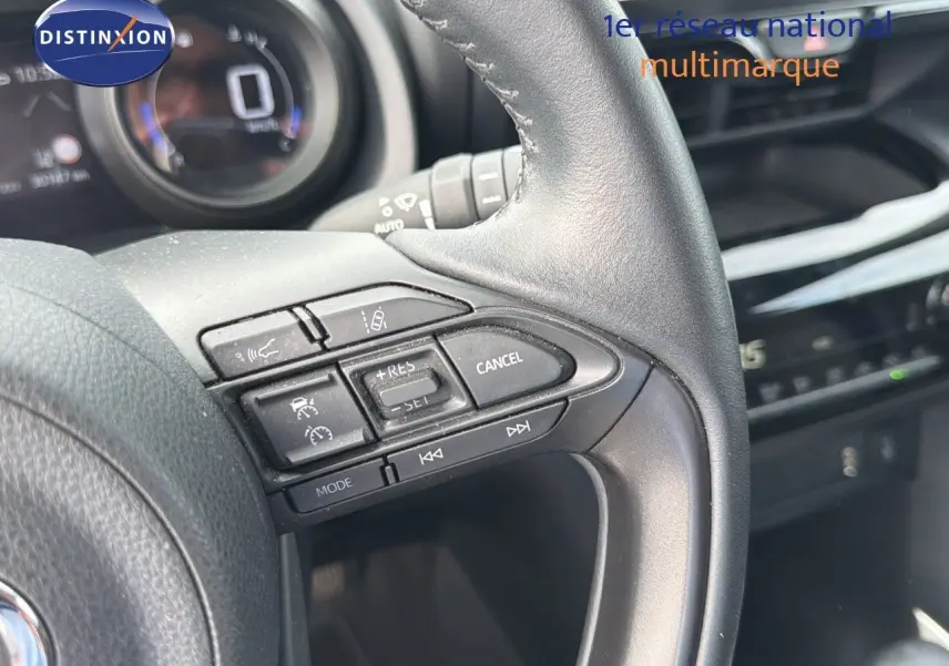 Gros plan sur les commandes au volant en cuir noir de la Toyota Yaris Cross 116h Design AWD-i 2023.