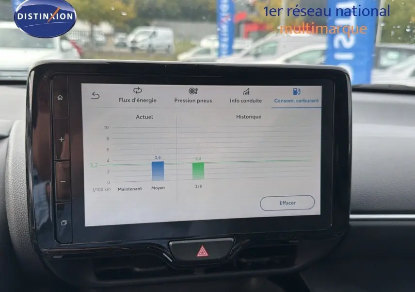 Écran tactile central affichant la consommation de carburant dans l'habitacle d'une Toyota Yaris Cross gris minéral 2023.