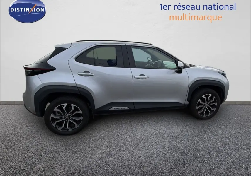 Profil droit d'une Toyota Yaris Cross gris minéral 2023 avec jantes bi-ton et détails noirs contrastants.