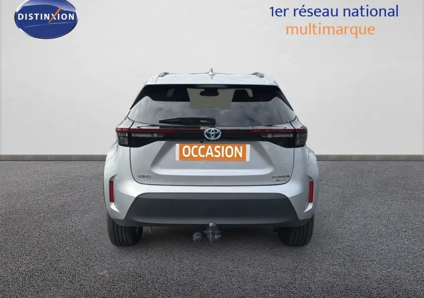 Vue arrière d'une Toyota Yaris Cross gris minéral 2023 avec attelage et feux LED distinctifs.