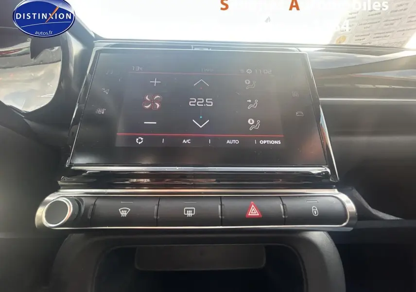 Vue rapprochée de l’écran tactile central et des commandes de climatisation d’une Citroën C3 gris foncé 2023.