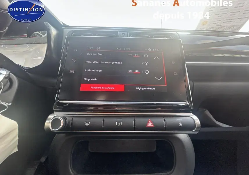 Vue rapprochée de la tablette tactile 7 pouces du tableau de bord de la Citroën C3 2023 gris foncé, avec commandes climatisation et alertes visibles.