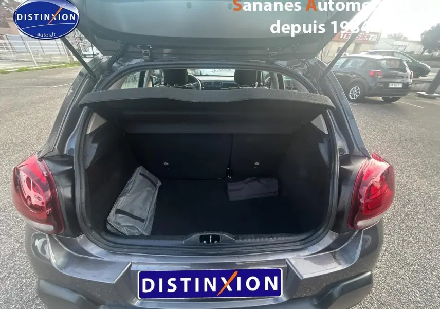 Coffre ouvert vu de l'arrière d'une Citroën C3 1.5 BlueHDi gris foncé 2023, avec objets à l'intérieur.